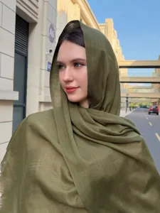 Detailed view of the solid olive green slub long scarf, worn outdoors, breathable fabric.