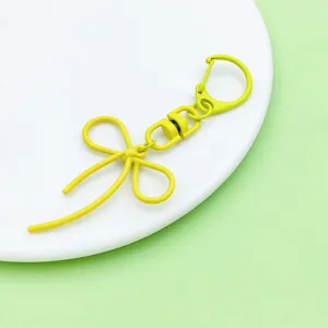 Detailed close-up view of the cute yellow alloy swivel keychain bowknot DIY accessory