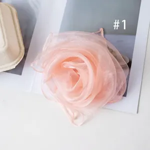 Pink organza flower scarf detail, lightweight sheer chiffon material, elegant accessory.