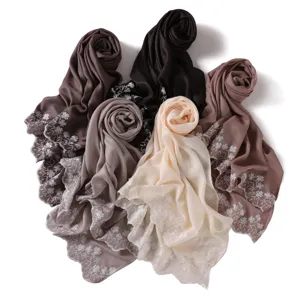 Elegant embroidered chiffon scarf detail showing exquisite floral patterns and glossy texture.