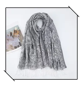 Detail view of the elegant paisley tassel scarf, showing fine texture and fringe accents.