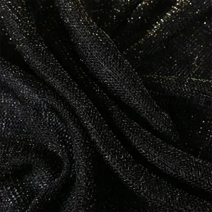 Detailed close-up of black and gold metallic glitter hollow knit fabric texture.