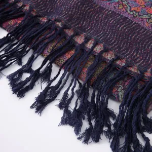 Close-up detail view of ethnic paisley woven scarf with classic navy blue fringe tassels.