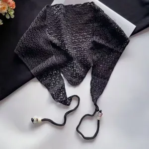 Detalle de pañuelo triangular de punto negro, bandana de ganchillo elegante con cuentas.