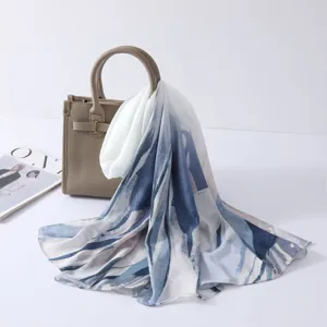 Detail view of a watercolor tie-dye printed satin polyester long scarf and chic shawl.