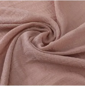Vue détaillée d'une écharpe unie en coton et lin froissé, texture douce et style élégant.
