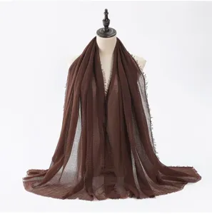Détail d'écharpe en coton et lin marron avec texture froissée et franges pour femme.