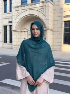 Detailed view of the dark green bubble hijab shawl worn by model outdoors, lightweight.