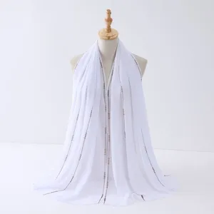 Dettaglio di sciarpa in chiffon bianco con catena di strass, elegante scialle.