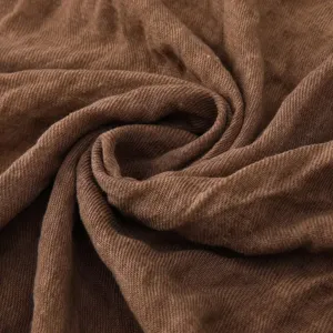 Brown cotton linen scarf fabric texture close-up detail shot showing natural wrinkles.