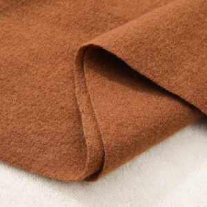 Close-up detail of soft cashmere-like brown fabric texture, highlighting warmth and fine weave.