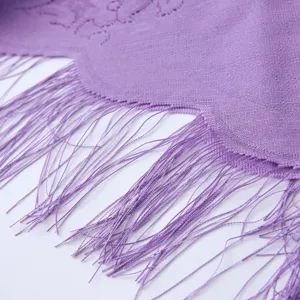 Close-up of a purple knitted triangular scarf featuring delicate lace hollow-out design and fringe.