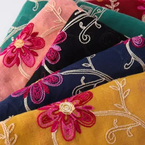 Detailed close-up shot of colorful linen scarves with exquisite floral embroidery patterns.