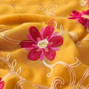Close-up of yellow embroidered floral shawl, rhinestone details, cotton linen scarf fabric.