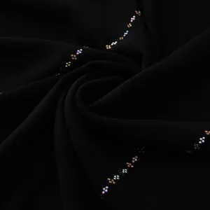 Dettaglio di sciarpa lunga in chiffon nero con motivo a catena di strass scintillante.