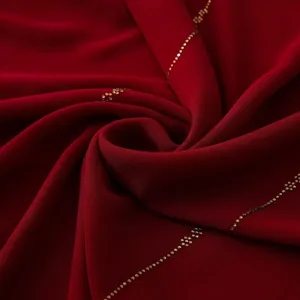 Primo piano dettagliato di un elegante foulard lungo in chiffon rosso con catene di strass.
