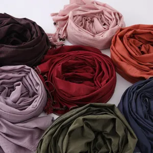 Fashionable multi-color rolled hijab scarf with tassels and metallic silver trim details.