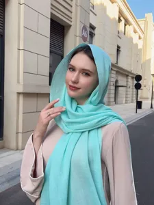 Detail view of the lightweight solid turquoise slub hijab scarf in outdoor casual styling.