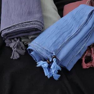 Detailed view of fashionable tassel hijab scarf with hanging beads and silver wire rolled edge.