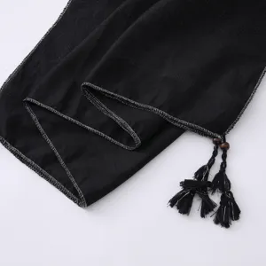 Close-up detail of black fashion hijab scarf featuring silver threaded edge and chic tassel beads.