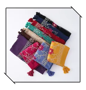 Detailed view of colorful embroidered scarves with fringe and tassels, cotton linen fabric.