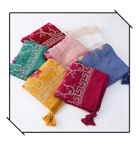 Close-up details of colorful embroidered linen scarves featuring elegant tassels and patterns.