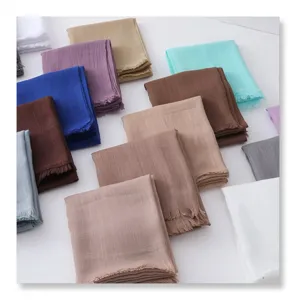 Detailed view showcasing a collection of colorful solid slub scarves with chic fringe edges.