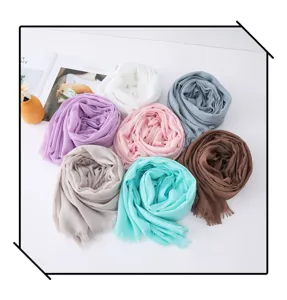 Detail shot of multi-color solid slub scarves rolled neatly on white surface for versatile outfits.