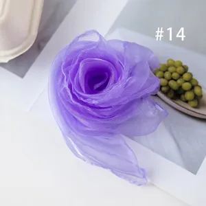 Purple chiffon square scarf detail shot, elegant rose flower folding design, soft fabric.