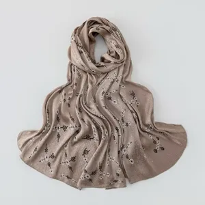 Close-up detail of pleated silk-feel scarf with delicate mini floral print texture.