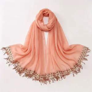 Detailed view of the peach chiffon hijab showcasing sequin embroidery and delicate tassels.