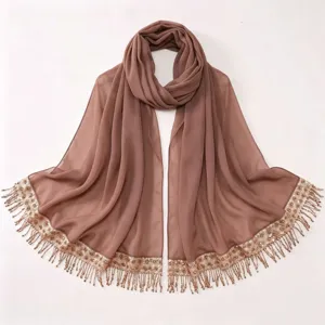 Detailed view of the elegant brown chiffon hijab featuring sparkling sequin and tassel fringe.