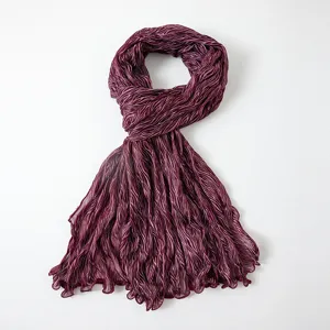 Close-up of shimmering crinkled striped bubble gauze scarf, showing delicate metallic texture.