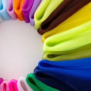 Close-up detail of colorful chiffon scarves, showing soft translucent texture and vibrant candy hues.