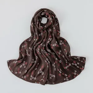 Detailed view of the dark brown floral silk scarf, showing delicate small flower print.