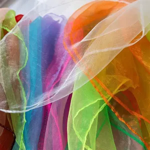 Close-up detail of colorful sheer chiffon scarves showing soft texture and vibrant candy colors.