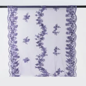 Close-up detail of the elegant purple floral embroidered lace fabric, showing delicate craftsmanship.
