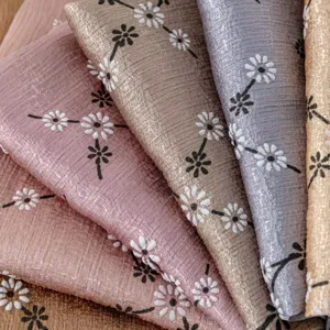 Close-up detail of pleated imitation silk scarf with delicate floral print texture.