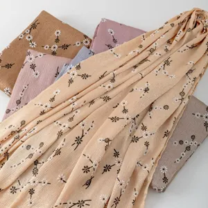 Close-up detail of floral printed silk-feel long scarf hijab with delicate daisy patterns.