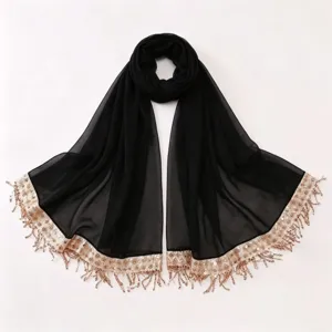 Details of black chiffon scarf with gold sequin and tassel trim, elegant fringe detail view.