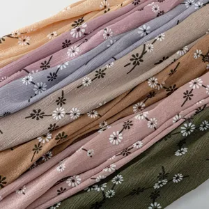 Detailed view of floral print silk-feel long scarf showing delicate daisy patterns and soft fabric texture.