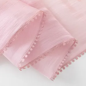 Close-up detail view of pink long scarf with delicate floral lace edge, soft fabric texture.