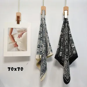Detailed view of fashionable paisley print silk square scarf showcasing delicate fabric pattern.