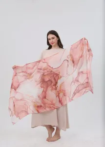 Watercolor print scarf detail showing pink gradient fabric texture and gold accent patterns.