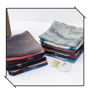 Detailed view of colorful watercolor printed gradient scarves stacked neatly, premium fabric texture.