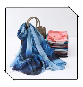 Detail view of women watercolor gradient silk scarf shawl draped over handbag and stacked.