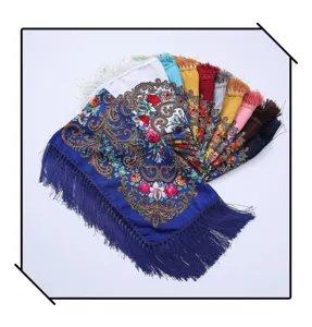 Close up view of colorful ethnic floral print square scarves with delicate fringe details.
