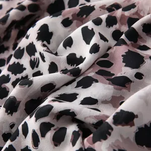 Close-up of watercolor tie-dye leopard print satin scarf fabric, showing fine soft texture.