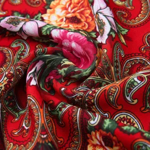 Close-up of vibrant red ethnic floral scarf with soft texture and paisley details.