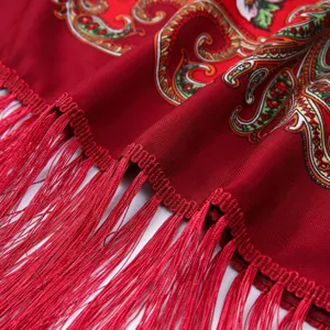 Red ethnic paisley print scarf close-up detail showing exquisite long tassels and soft fabric texture.